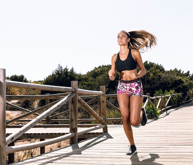 Long shot woman running on pier