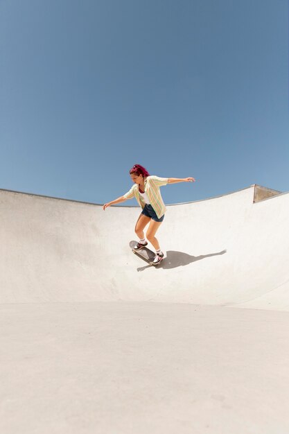 Long shot woman on skateboard outside