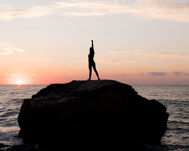 Long shot woman in sportswear enjoying the sunset