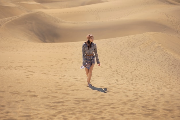 Free Photo long shot woman walking in desert