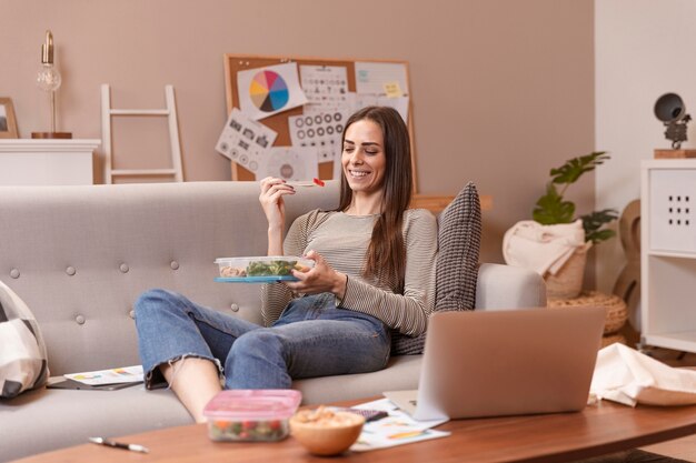 Long shot of woman working and eating