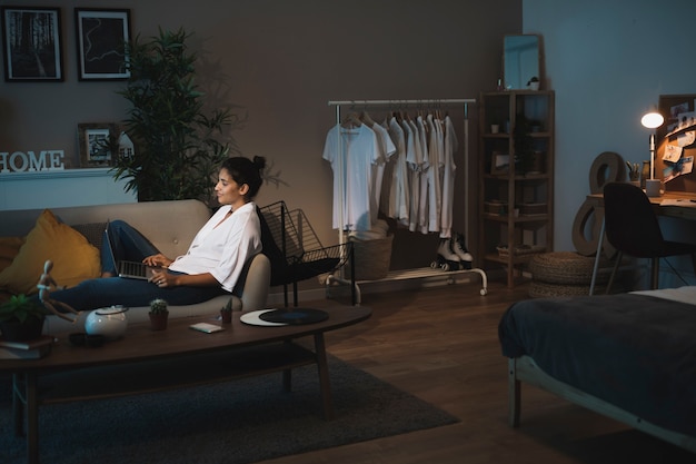 Long shot woman working on laptop from home