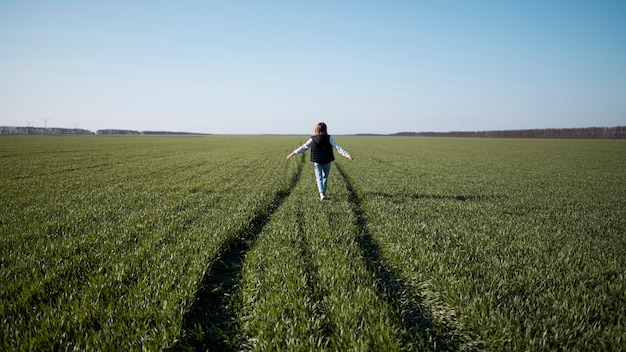 Free photo long shot of young girl in the field