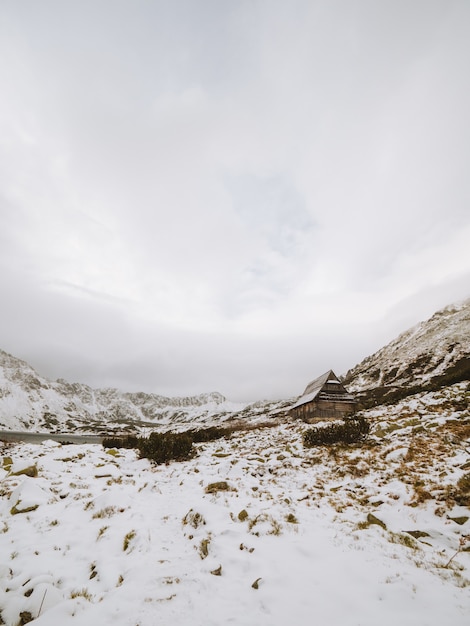 Free photo long vertical shot of a winter landscape with a small cabin at the tatra mountains in poland