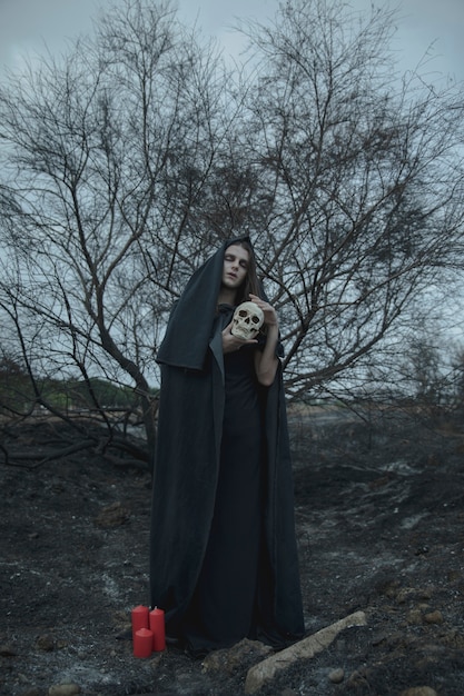 Long view portrait of a man in the night with skull