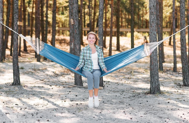 Free Photo long view woman sitting in hammock