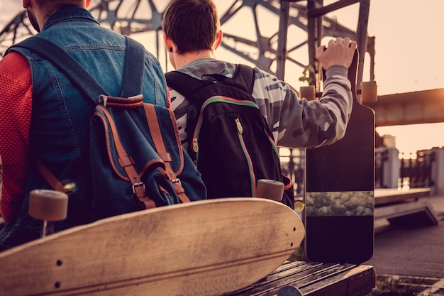 Free Photo longboard and backpack on a bench in a city.