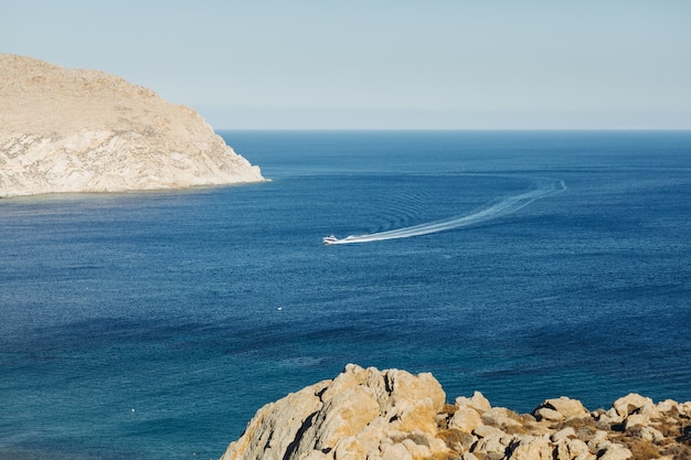 Free photo look from afar at the boat crossing the sea somewhere in greece