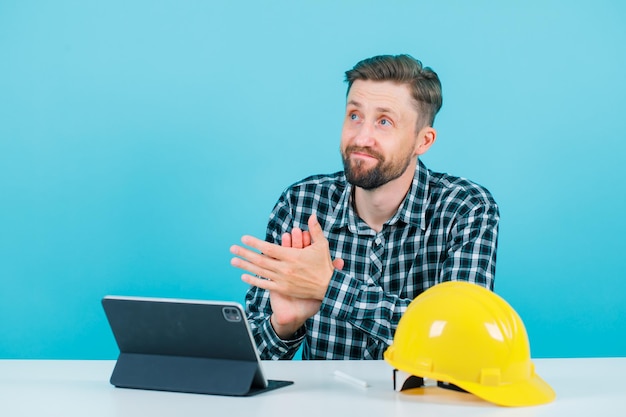 Free Photo looking up architect is aplauding by sitting in front of tablet on blue background