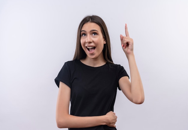 Looking at up joyful young caucasian girl wearing black t-shirt points to up with finger on isolated white background