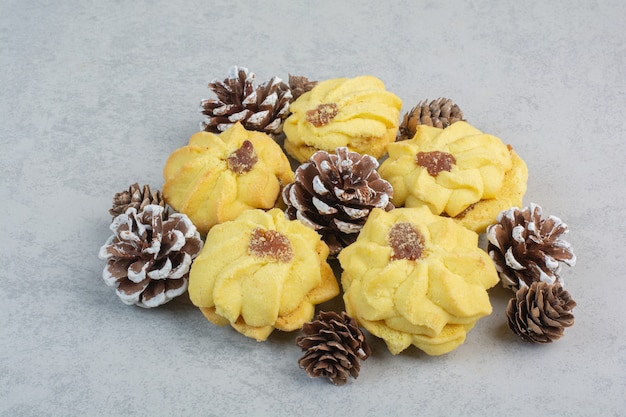 Free photo a lot of fresh delicious cookies with small pinecones on white table.