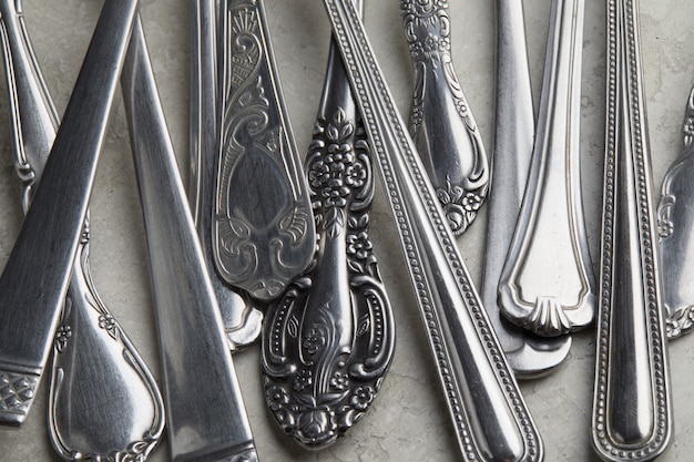 Free Photo lot of silver forks and spoons with antique patterns on a white surface