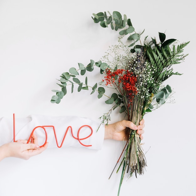 Love concept with hand holding wildflowers