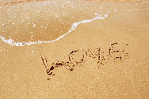 Free photo love inscribed in the sand of a beach