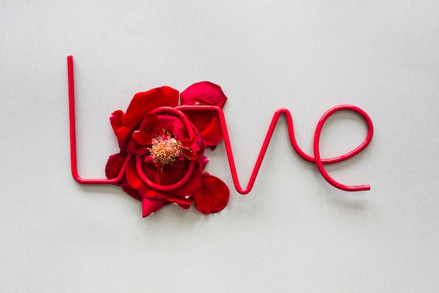 Free Photo love inscription on red rose petals on table