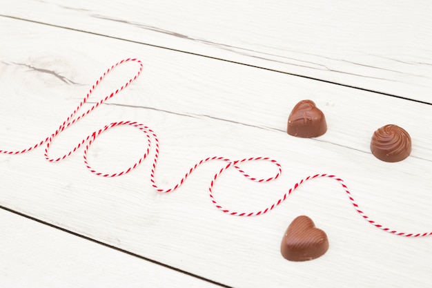 Free Photo love inscription of thread near chocolate hearts