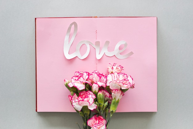 Free photo love inscription with flowers on notebook