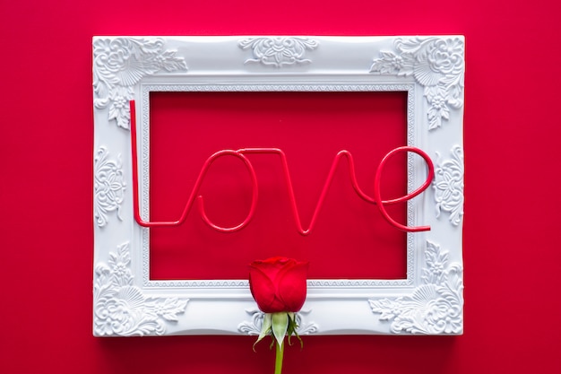 Free Photo love inscription with frame and rose on table