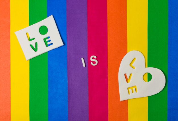 Love is love words on tablets on bright LGBT flag