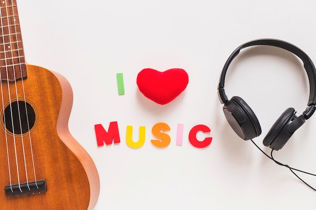 Free photo love music text between the musical guitar and headphone on white background