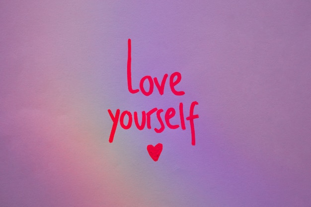 Free photo love yourself inscription on purple paper