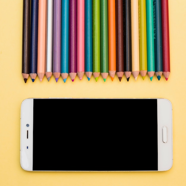 Free Photo lovely artist concept with colorful pencils and smartphone