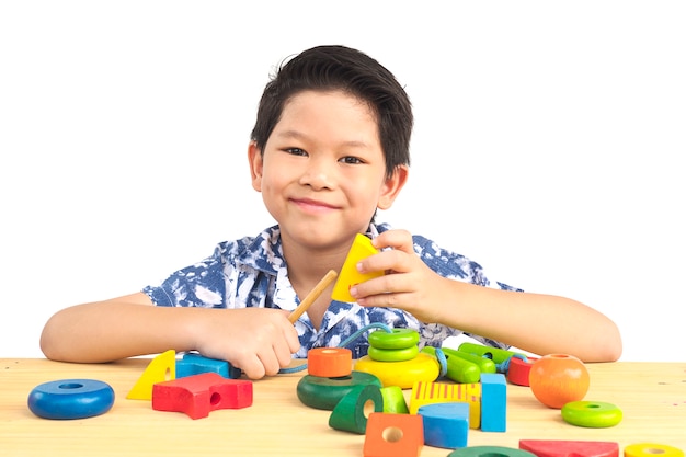 Lovely asian boy is play colorful wood block toy