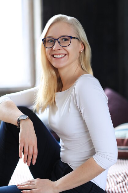 Free photo lovely blonde woman with eyeglasses posing in white shirt