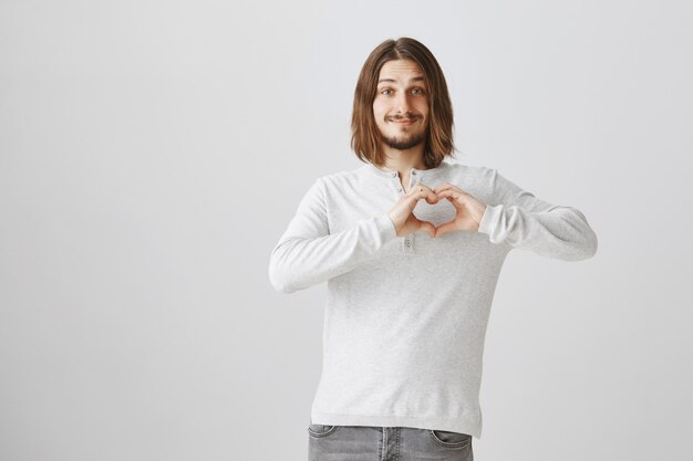 Lovely boyfriend showing heart gesture, express love and care