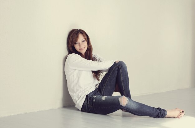 Lovely and charming adult woman sitting on floor