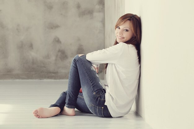 Lovely and charming adult woman sitting on floor