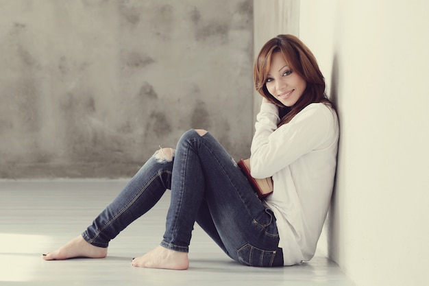 Lovely and charming adult woman sitting on floor