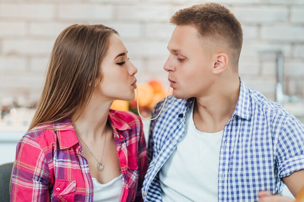 Free Photo lovely cople with spaghetti, kiss in kitchen.