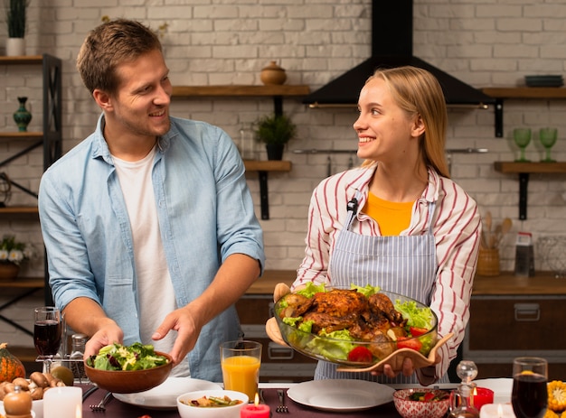 Lovely couple holding the food and looking at each other