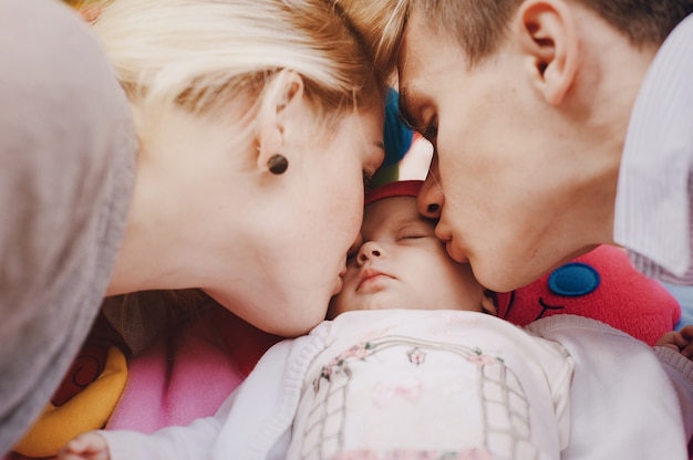 Free Photo lovely couple kissing their daughter