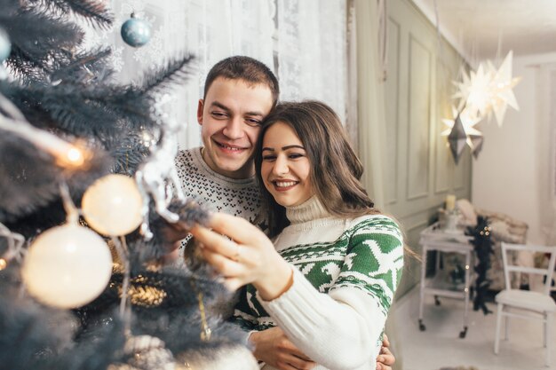 The lovely couple in love decorated a Christmas tree