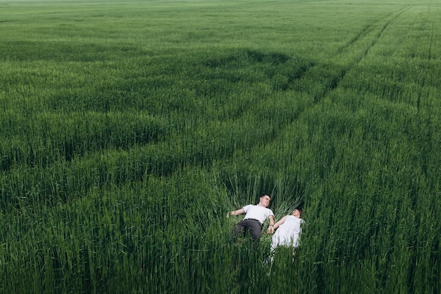 The lovely couple in love lie on the field