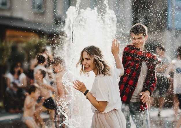 The lovely couple in love playing with fountain