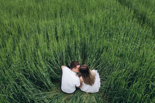 Free photo the lovely couple in love sitting  on the field