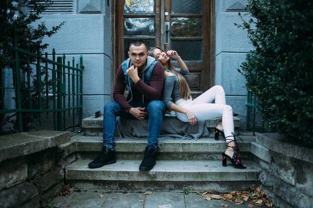 The lovely couple in love sitting on the stairs