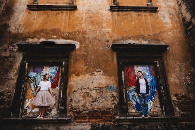 The lovely couple in love standing on the windows