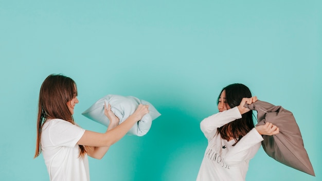 Lovely friends fighting with pillows