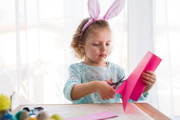 Lovely girl cutting Easter decorations