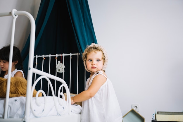 Free photo lovely girl standing near bed