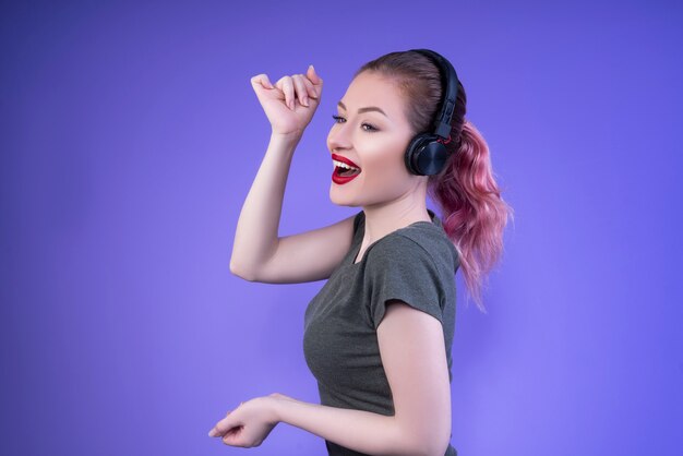 Lovely half-turned woman with red lips smiling and enjoying the music