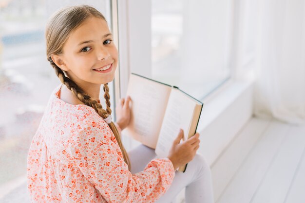 Lovely happy girl posing with a book