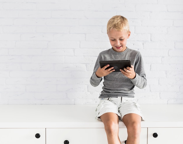 Free Photo lovely little boy having fun with tablet