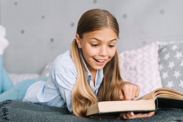 Free photo lovely little girl reading a book