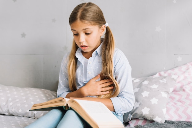 Lovely little girl reading a book