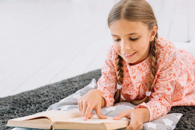 Free photo lovely little girl reading a book